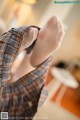 A close up of a person's feet in a plaid shirt.