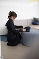 A woman sitting on the floor holding a blue purse.