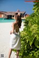 A woman in a white dress standing on a beach.