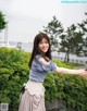 A woman in a blue shirt and a pink skirt posing for a picture.