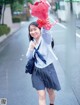 A young woman in a school uniform holding a bunch of flowers.