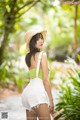 A woman in a straw hat is posing for a picture.