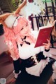 A woman with pink hair is reading a book.