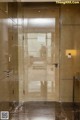 A glass elevator door in a building with a marble floor.