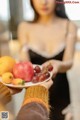 A woman holding a plate of fruit in her hands.