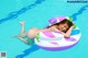 A pregnant woman laying on an inflatable ring in a swimming pool.