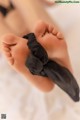 A close up of a baby's feet with a black bow.