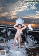 A woman in a white bikini standing on a balcony covered in foam.