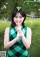 A woman in a green and black dress posing for a picture.