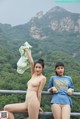 A couple of women standing next to each other on a bridge.