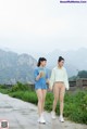 A couple of women walking down a road holding hands.