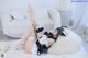 A woman laying on top of a white couch next to a teddy bear.