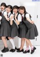 A group of young women in school uniforms posing for a picture.