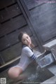 A woman in a white bodysuit sitting in a pool of water.