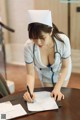 A woman in a nurse uniform writing on a piece of paper.