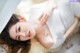 A woman laying on the floor under a white sheet.