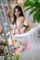 A woman sitting in a bathtub surrounded by flowers.