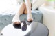 A woman sitting on top of a table with her feet on the table.