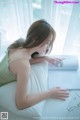 A woman laying on a bed reading a book.