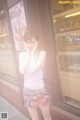 A woman standing in front of a bakery talking on a cell phone.