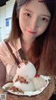 A woman holding a coconut with three scoops of ice cream.