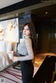 A woman standing in a hotel room holding a cup of coffee.