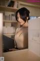 A woman is looking at a book in a library.