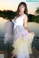 A woman in a white dress standing on a bridge.
