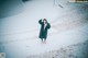 A woman wearing a face mask standing in the snow.