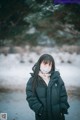 A woman wearing a face mask standing in the snow.