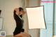 A woman sitting on top of a table next to a light.