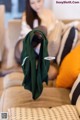 A woman sitting on a couch holding a green scarf.