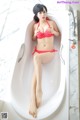 A woman in a red bikini sitting in a bathtub.