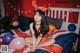 A woman in bunny ears sitting on a bed with balloons.