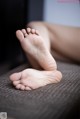 A close up of a person's bare feet on a couch.