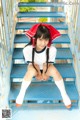 A woman in a school uniform sitting on a set of stairs.