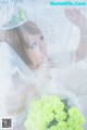 A woman in a wedding dress holding a bouquet of green roses.