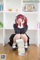 A woman sitting on top of a pile of books.