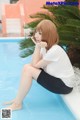 A woman sitting on the edge of a swimming pool.