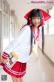 A woman in a school uniform holding a book.