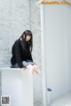 A woman sitting on top of a white box.