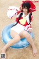 A woman in a red and white outfit sitting on an inflatable ring.