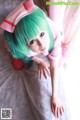 A woman with green hair wearing a pink nurse outfit.