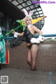 A woman dressed as a bunny holding a green stick.