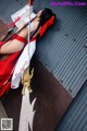 A woman in a red and white outfit holding a sword.