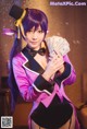 A woman in a purple and black outfit holding a bunch of money.