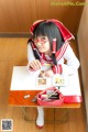 A woman sitting at a desk writing in a book.