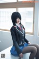 A woman in a school uniform sitting on a table.