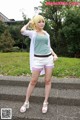 A woman in white shorts and a green shirt posing for a picture.