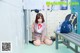 A woman sitting on the floor in front of lockers.